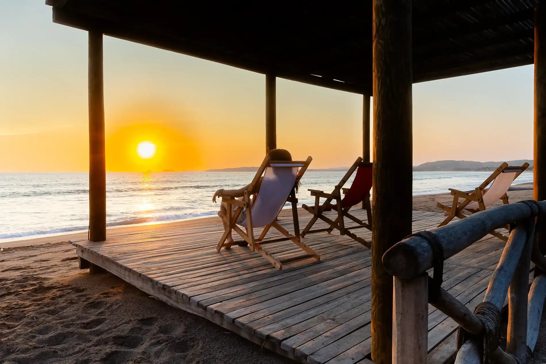 Terraza de Aramar Palafitos frente al océano al atardecer